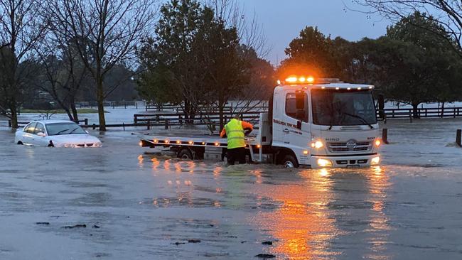 A car is towed out of rising floodwaters near Traralgon. Picture: Jenni Rohde