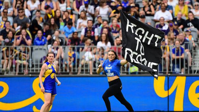 A streaker invades the field holding a ‘Right to Rescue banner.