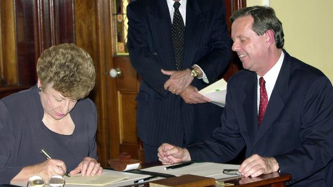 New Premier Mike Rann manages a smile as Govenor Marjorie Jackson-Nelson signed him in as Premier in 2002. Picture: AAP Image/Tom Miletic