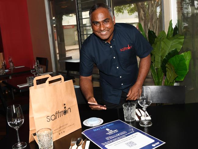 Saffron Restaurant owner Selvam Kandasamy with the new Territory Check In system. Picture: Katrina Bridgeford