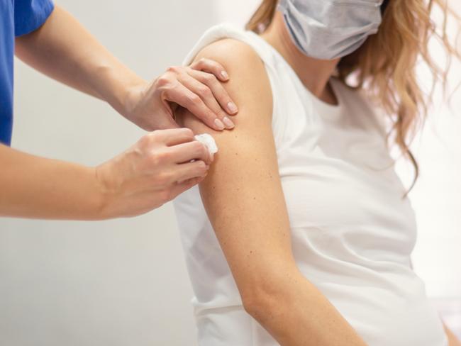 Applying a COVID-19 vaccine to a pregnant woman