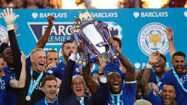 Leicester City's Claudio Ranieri (C) and Wes Morgan hold up the Premier league trophy.