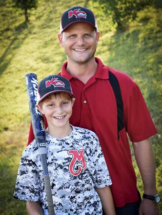 Caleb Thomas with his father Scott Schwab. Picture: David Strickland via AP.