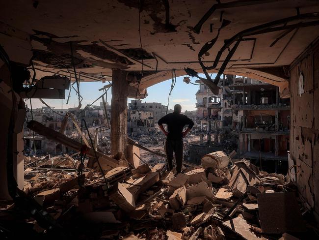 TOPSHOT - A man stands on an elevated floor in a heavily-damaged building without walls in Rafah in the southern Gaza Strip on January 21, 2025, as residents return following a ceasefire deal in the war between Israel and Hamas in the Palestinian territory. (Photo by Eyad BABA / AFP)