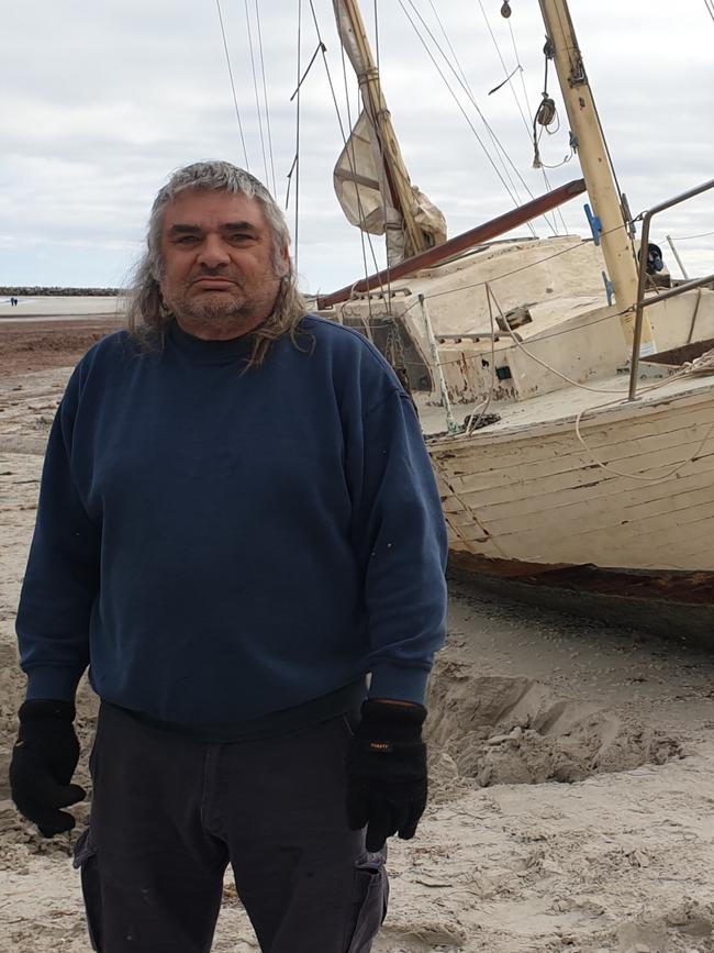 Novice sailor Claude Evans with his stranded yacht at North Haven. Picture: Colin James