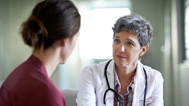 Shot of a compassionate doctor comforting a young woman in a hospital waiting room; fear health scare generic