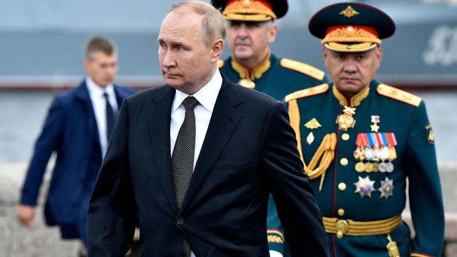 Russian President Vladimir Putin, flanked by Defence Minister Sergei Shoigu, right, in a naval parade in St. Petersburg in July. Picture: AFP