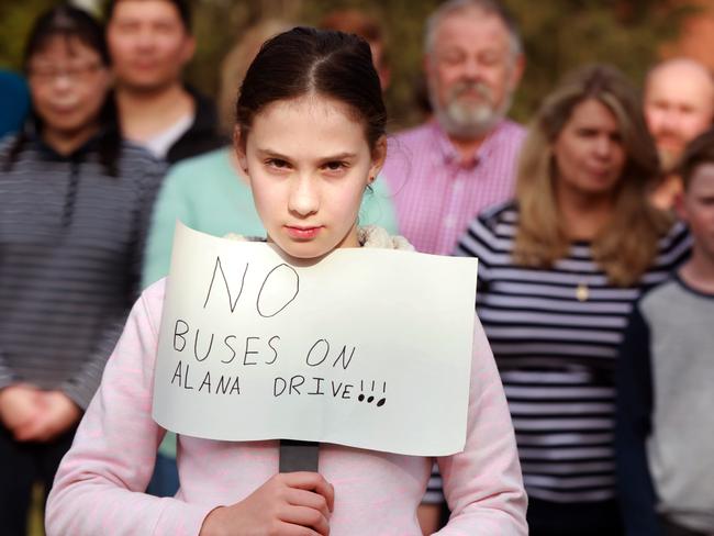 10 year old Sophie Hopwood poses for photographs holding a sign protesting the proposed bus stops for Alana Dr, West Pennnant. West Pennant Hills, Saturday, July 28th 2018. 90 residents signed a petition to prevent bus stops going in at Alana Dr, West Pennnant. They don't want these bus stops to be installed outside their homes because of a lack of consolation. (AAP Image / Angelo Velardo)