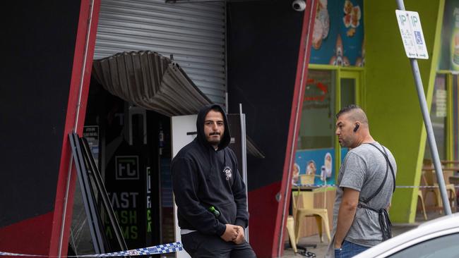 Police speak to some men out the front of the store. Picture: Jason Edwards