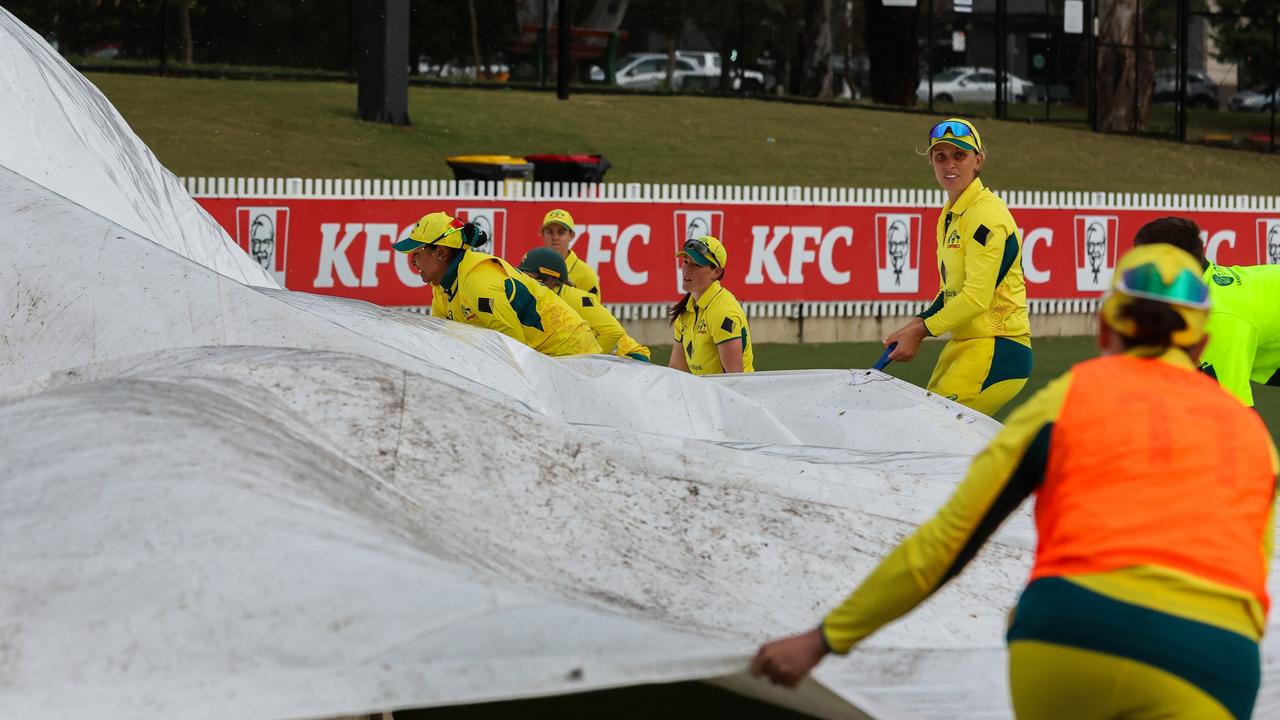 Australian players assist ground staff in carrying the pitch covers. Picture: Asanka Ratnayake / Getty Images