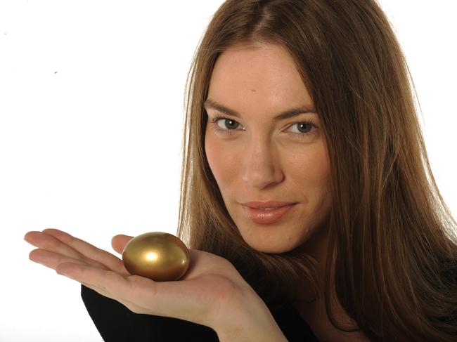 Your Money superannuation generic images. Woman holding golden nest egg in her hand.