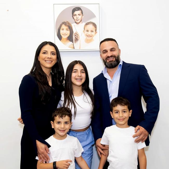 Leila and Danny Abdallah with their children Liana, Alex and Michael, in front of a portrait of the children they lost — Antony, Angelina and Sienna. Picture: Supplied