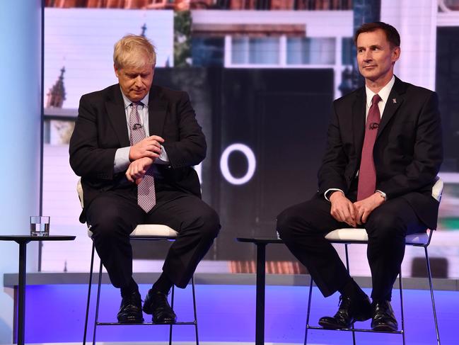 In a handout picture released by the British Broadcasting Corperation (BBC) on June 18, 2019 Conservative Party leadership contender Conservative MP Boris Johnson (L) checks his watch seated next to Britain's Foreign Secretary Jeremy Hunt (R) during a BBC television leadership debate in London on June 18, 2019. - The UK leadership race narrowed to five in a second vote by MPs on June 18 with the remaining contenders taking part in a televised debate organised by the BBC. (Photo by JEFF OVERS / BBC / AFP) / RESTRICTED TO EDITORIAL USE - MANDATORY CREDIT " AFP PHOTO / JEFF OVERS-BBC " - NO MARKETING NO ADVERTISING CAMPAIGNS - DISTRIBUTED AS A SERVICE TO CLIENTS TO REPORT ON THE BBC PROGRAMME OR EVENT SPECIFIED IN THE CAPTION - NO ARCHIVE - NO USE AFTER  JULY 9, 2019 /