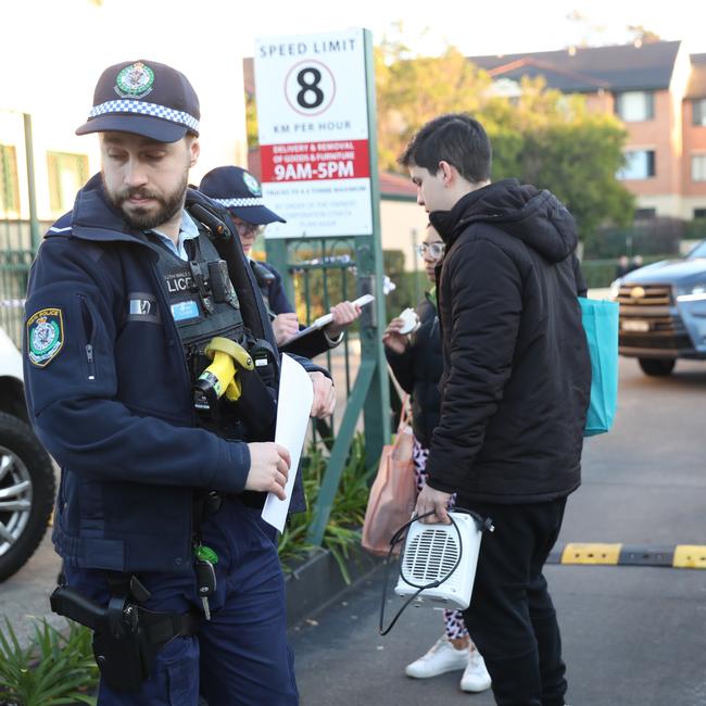 Police check residents at the block today. Picture: John Grainger