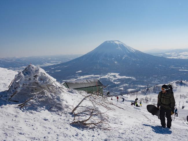 Snowboarders hike up the Backcountry Trail at Mt Annupuri in Niseko.