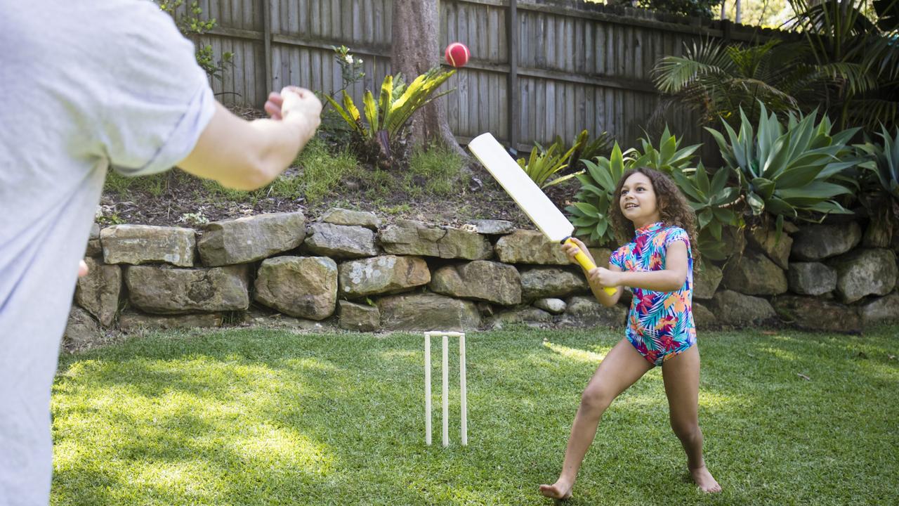 Father and daughter playing cricket in the garden