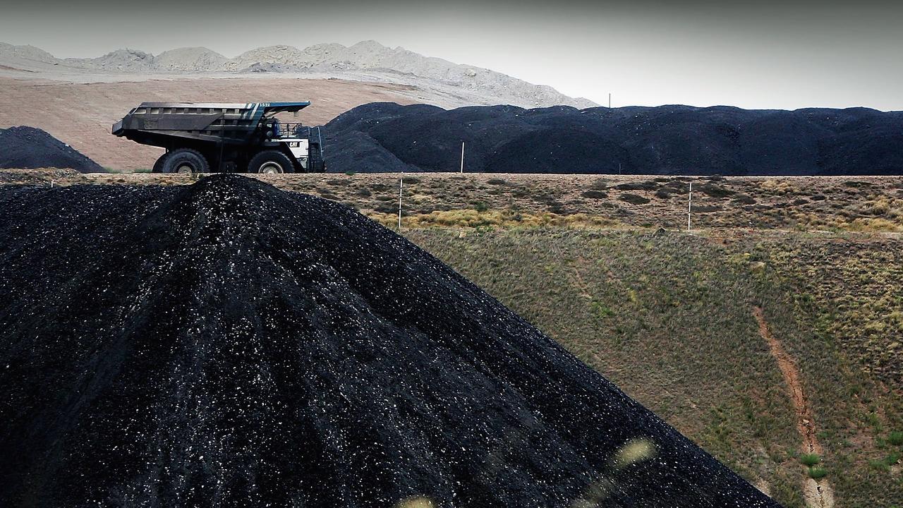 A coal truck passes a huge pile of coal at BHP's Mt Arthur coal mine. Picture: Getty Images