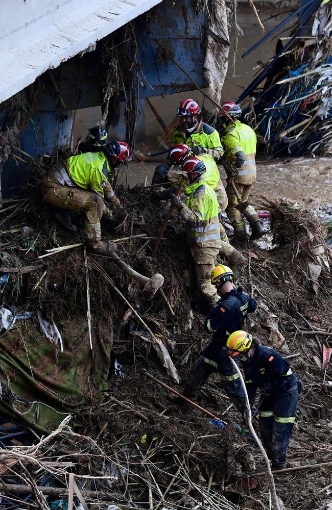 Firefighters clear debris in Paiporta. Picture: AFP