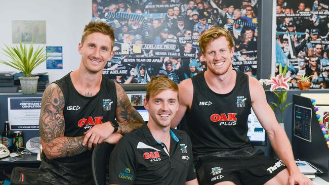 Star East Torrens cricketer Michael Cranmer, who works in the media department at the Port Adelaide footy club, with Power players Hamish Hartlett and Tom Jonas. Picture: AAP Image/ Brenton Edwards