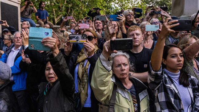 Members of the public, inside the green walls, watch the cortege carrying the coffin of Queen Elizabeth II. Picture: Louise Delmotte/Getty Images