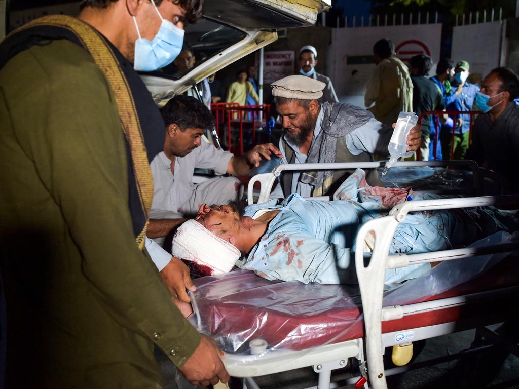 Medical staff bring an injured man on a stretcher for treatment after two blasts, which killed at least five and wounded a dozen, outside the airport in Kabul. Picture: AFP