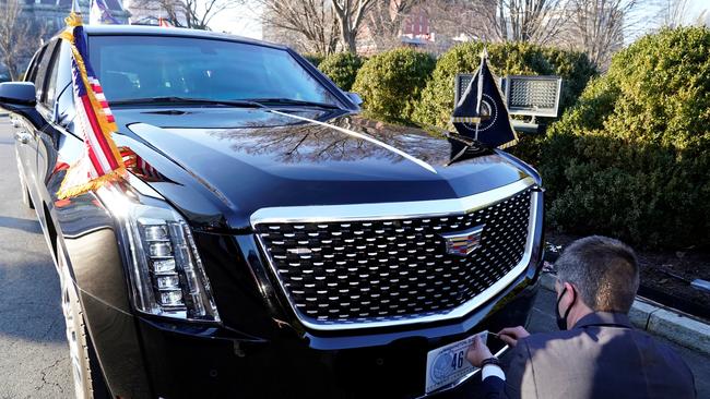 A Secret Service agent changes the number plate on President Biden's car. Picture: Reuters