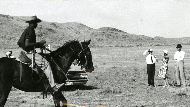 Queen Elizabeth II's 1963 royal visit to Australia. The Queen and Prince Philip, the Duke of Edinburgh, standing amid the dust watching cattle being mustered by stockmen at Hamilton Downs station, 67 miles west of Alice Springs, NT, 16 March 1963. On the Queen's right is station manager Bill Prior.