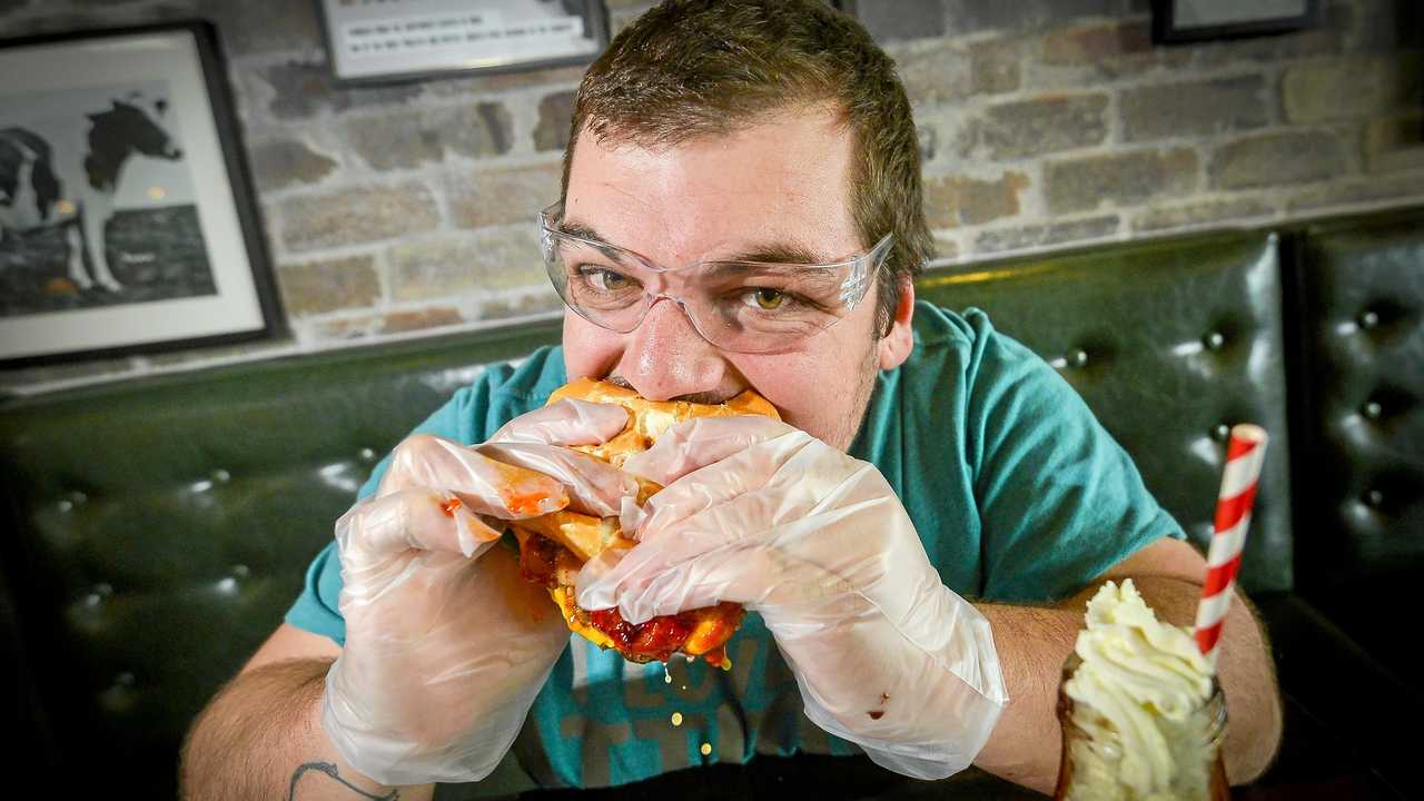 HEATED SITUATION: Brenton Rouvray bravely devoured the Double Decker Death Wish burger at Gladstone's Stockland shopping centre on July 11, 2018. Picture: Matt Taylor GLA110718BURG