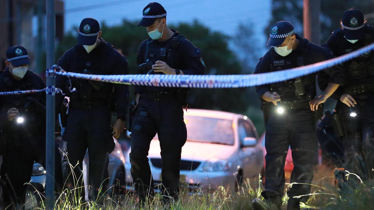 Police comb a crime scene after a gangland shooting. Picture: Christian Gilles