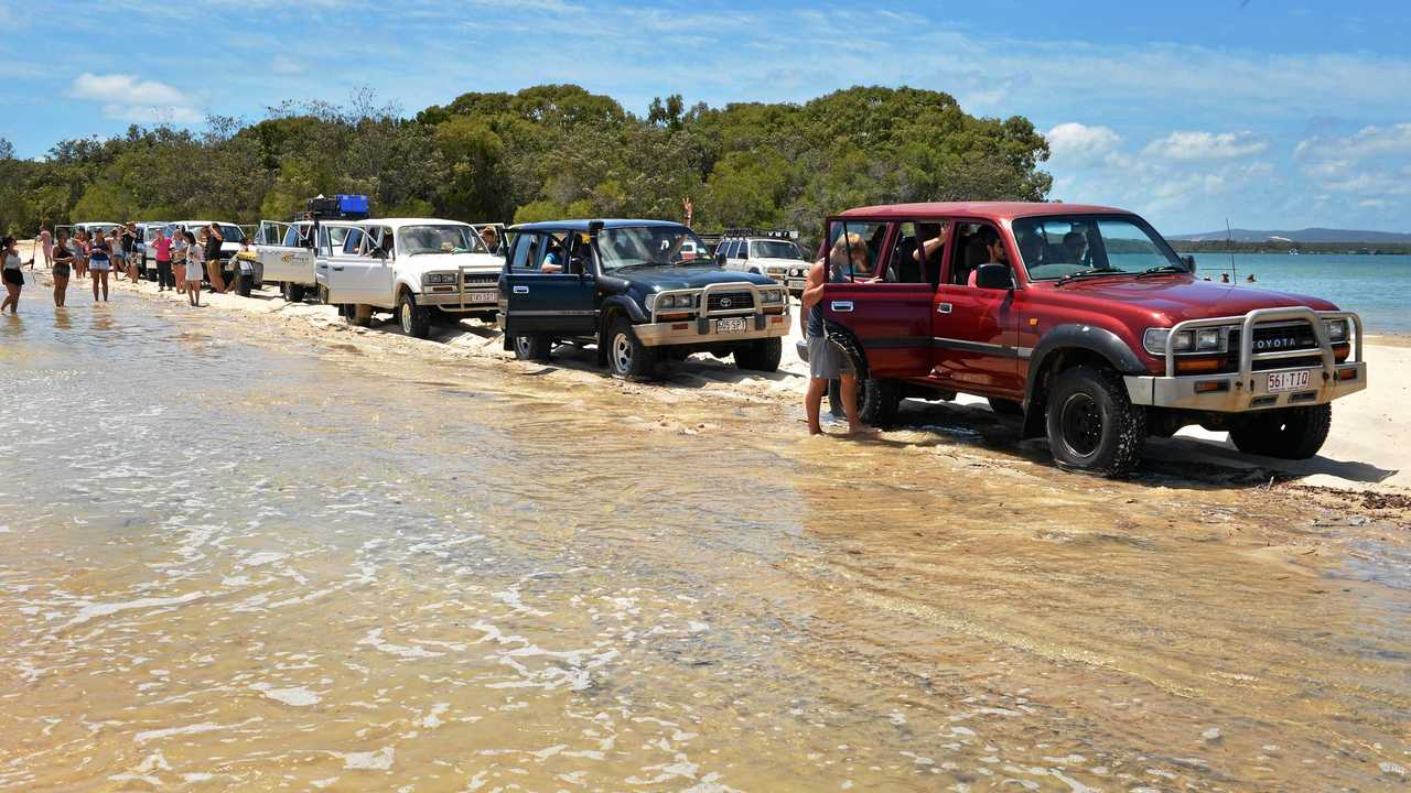 A 2.2m high tide at Inskip Point gives four-wheel-drives some beach challenges lining up for the Fraser Island barge. Picture: Greg Miller