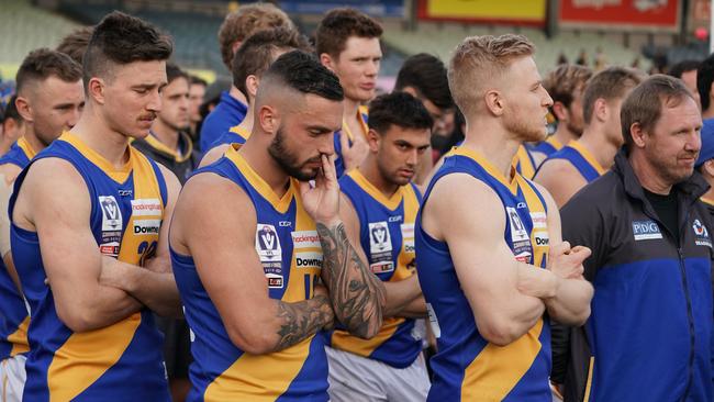 Dejected Williamstown players and coach Andy Collins (right) at the presentation.