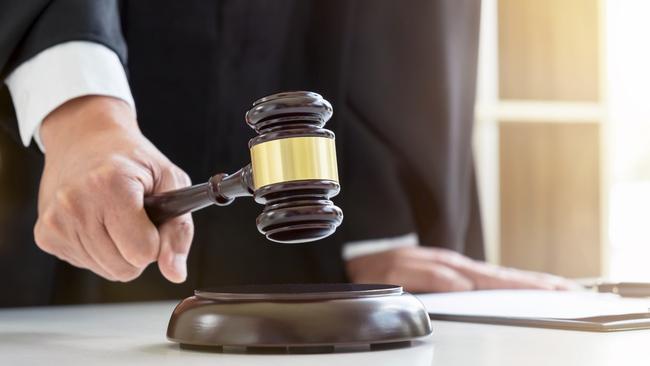 Close up of Male lawyer or judge hand's striking the gavel on sounding block, working with Law books, report the case on table in modern office, Law and justice concept.