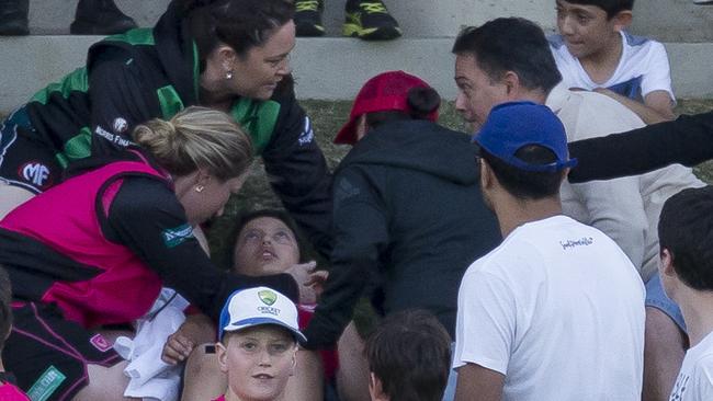 The spectator is treated after being hit by an Ellyse Perry six at North Sydney Oval on Saturday night.