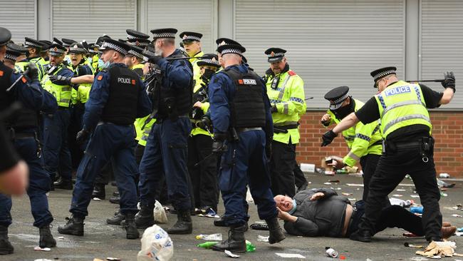 A protester falls behind the police line as people are moved on outside Old Trafford stadium. Picture: AFP