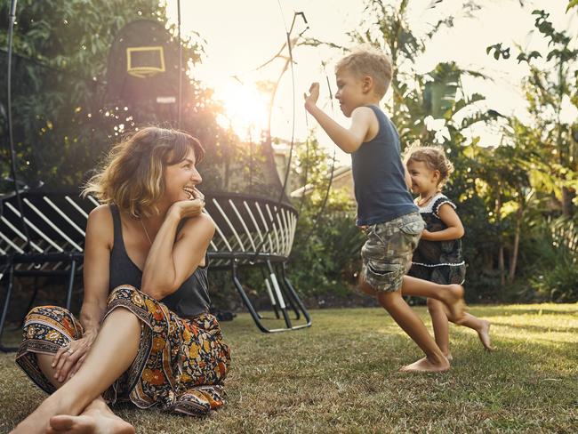 Shot of a young mother hanging outside with her son and daughter