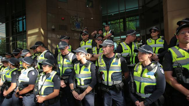 Victoria Police officers stand guard as Cardinal George Pell arrives at court. Picture: AAP Image/Stefan Postles