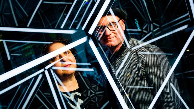 Illuminate Adelaide creative directors Rachael Azzopardi and Lee Cumberlidge reflected in Jason Sims’ Golden Rhombohedron light sculpture. Picture: Mike Burton