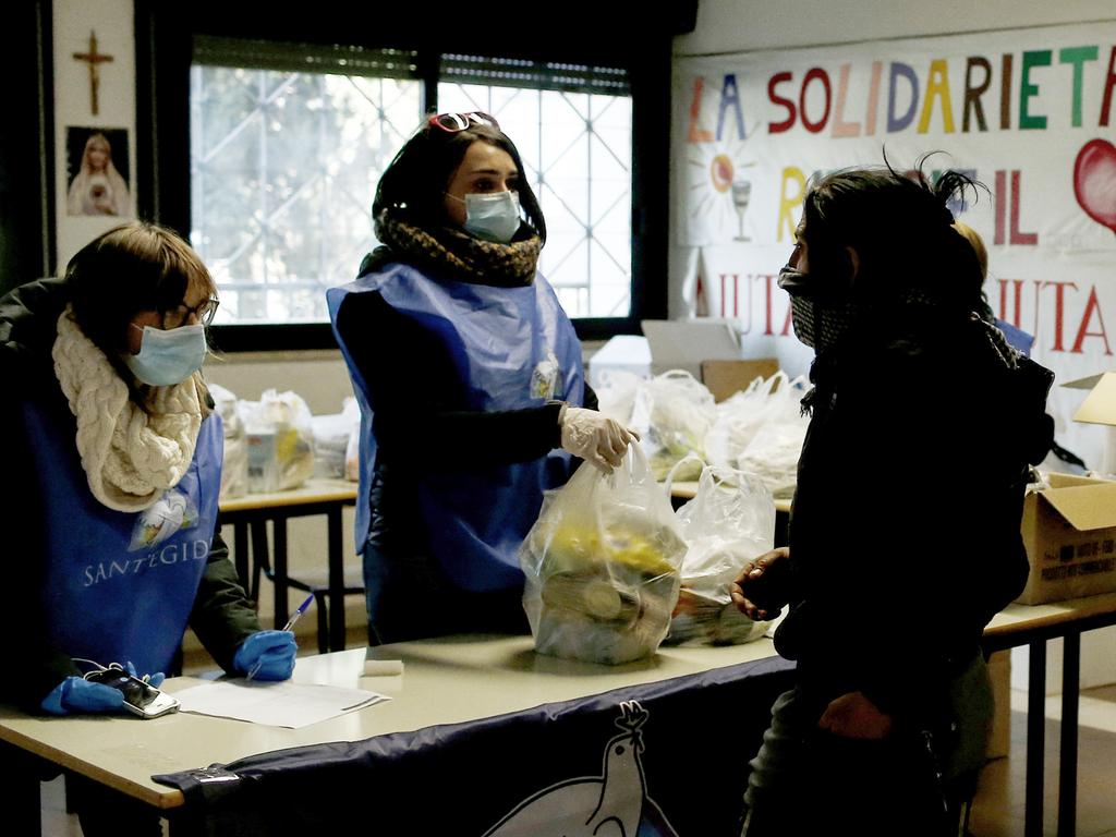 Volunteers distribute food to families in need in Rome. Picture: AP