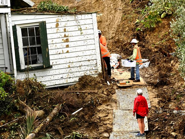 Workers work to clear belongings from a property where an a man was found dead after a landslide hit in Remuera in Auckland, New Zealand. Picture: Getty Images