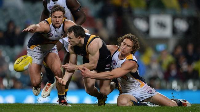 Eagle Matt Priddis tires to stop Nathan Foley dishing off a handball. Picture: Daniel Wilkins