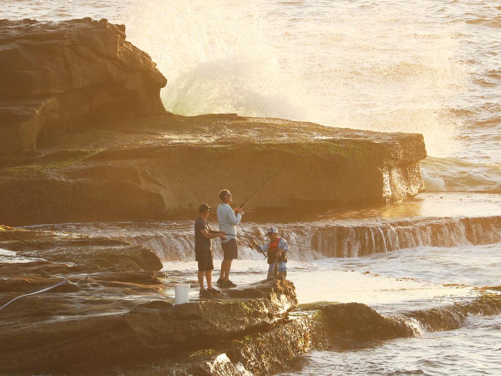 Fishermen at the spot where a man was taken by a shark. Picture: John Grainger