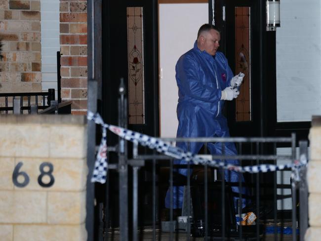 Police and Forensic services officers at the Manrique’s Davidson home last night. Picture: Bill Hearne