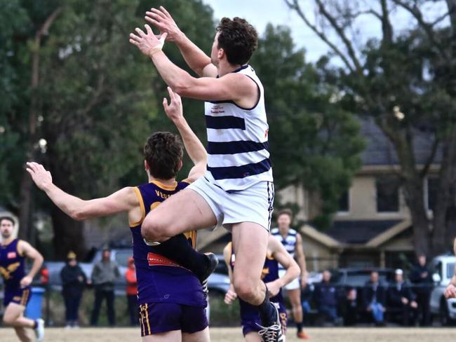 Nick Komen flies for a mark. Picture: Davis Harrigan