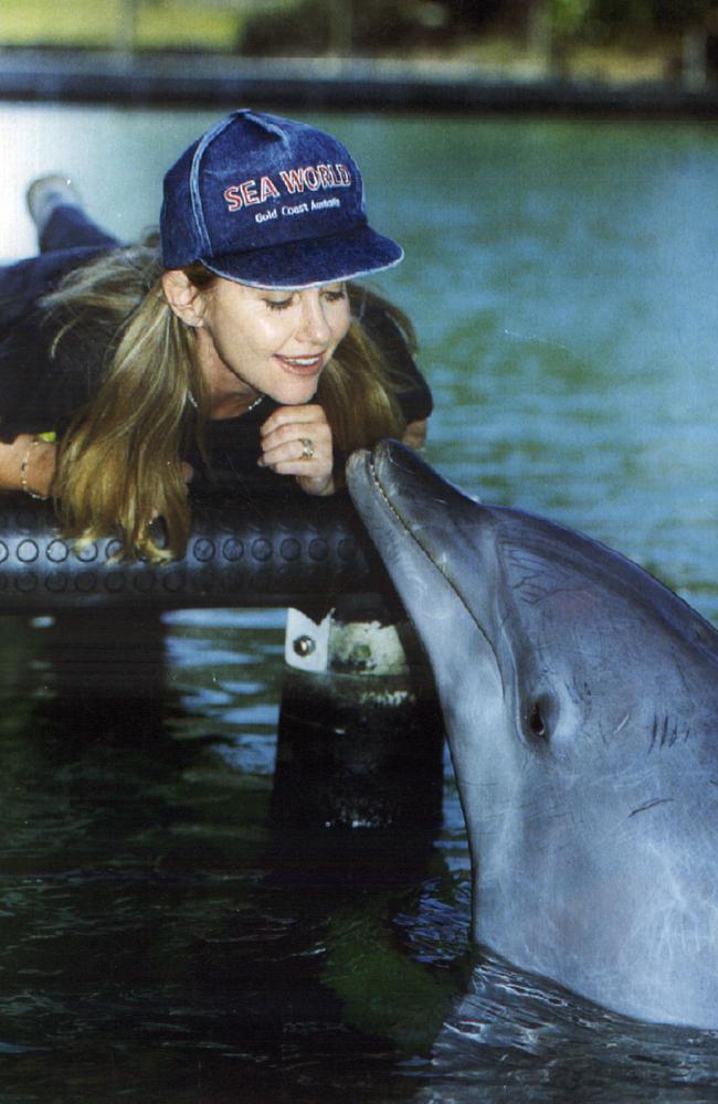 Newton-John meets one of the resident Dolphins at Sea World on the Gold Coast. Picture: Paul Riley