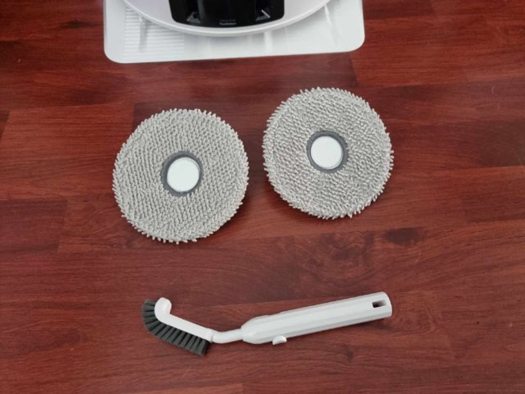 Two mop pads and a cleaning brush on a hardwood floor ridden with my dog's pet hair. Picture: news.com.au/Tahnee-Jae Lopez-Vito.