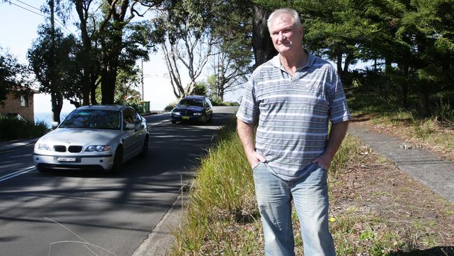 Resident Craig Jowett is calling for the removal of a series of large gum trees which obscure traffic coming on the Scenic Highway. Picture: Mark Scott