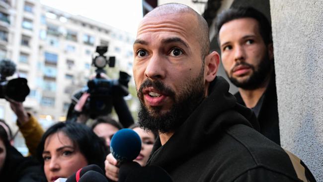 British-US former professional kickboxer and controversial influencer Andrew Tate (front) and his brother Tristan Tate (back R) speak to journalists after having been released from detention in Bucharest, Romania on March 12, 2024, after they appeared in a Bucharest court after Romanian police detained them over UK sex offence charges. A Bucharest court on March 12 granted a request to extradite controversial influencer Andrew Tate to the UK over sex offence charges, but only after the conclusion of legal proceedings in Romania in a separate case. The Bucharest appeals court ruling "orders the execution of the warrant of arrest issued on 19 January 2024" by the Westminster Magistrates' Court, but postpones extradition "until the final resolution of the case" in Romania, which could take years. (Photo by Daniel MIHAILESCU / AFP)