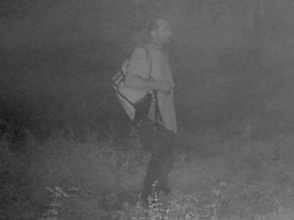 The deer camera footage shows a man with a backpack.