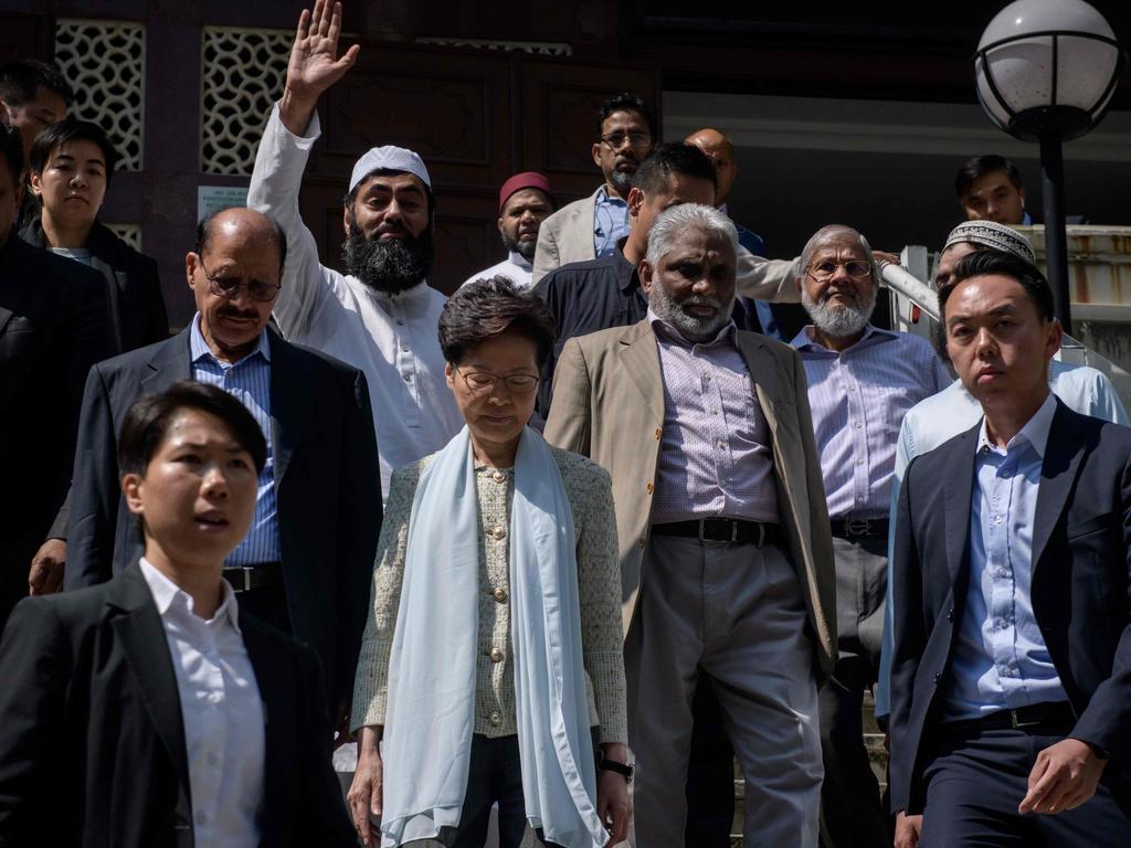 Hong Kong's Chief Executive Carrie Lam (C) exits the Kowloon Mosque, or Kowloon Masjid and Islamic Centre that was struck with blue dye from a water cannon truck. Picture: AFP