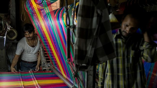 Silk weavers at work in the factory of Mohammad Hashim that produces the famous Banaras silk in Uttar Pradesh, India. Photo by Graham Crouch/The Australian